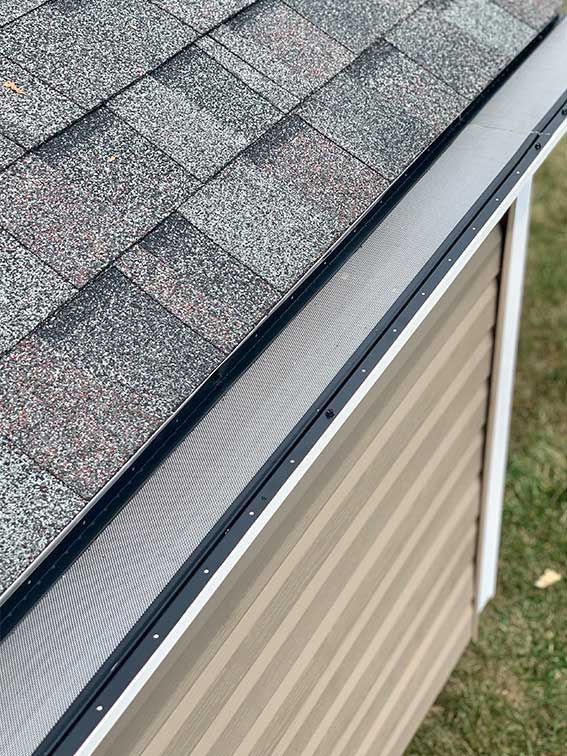 A close up of a gutter on the side of a house.