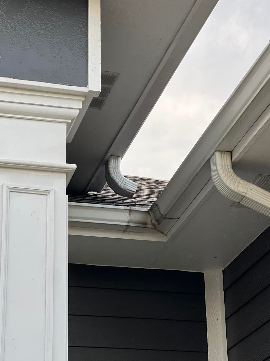 A close up of a gutter on the side of a house.