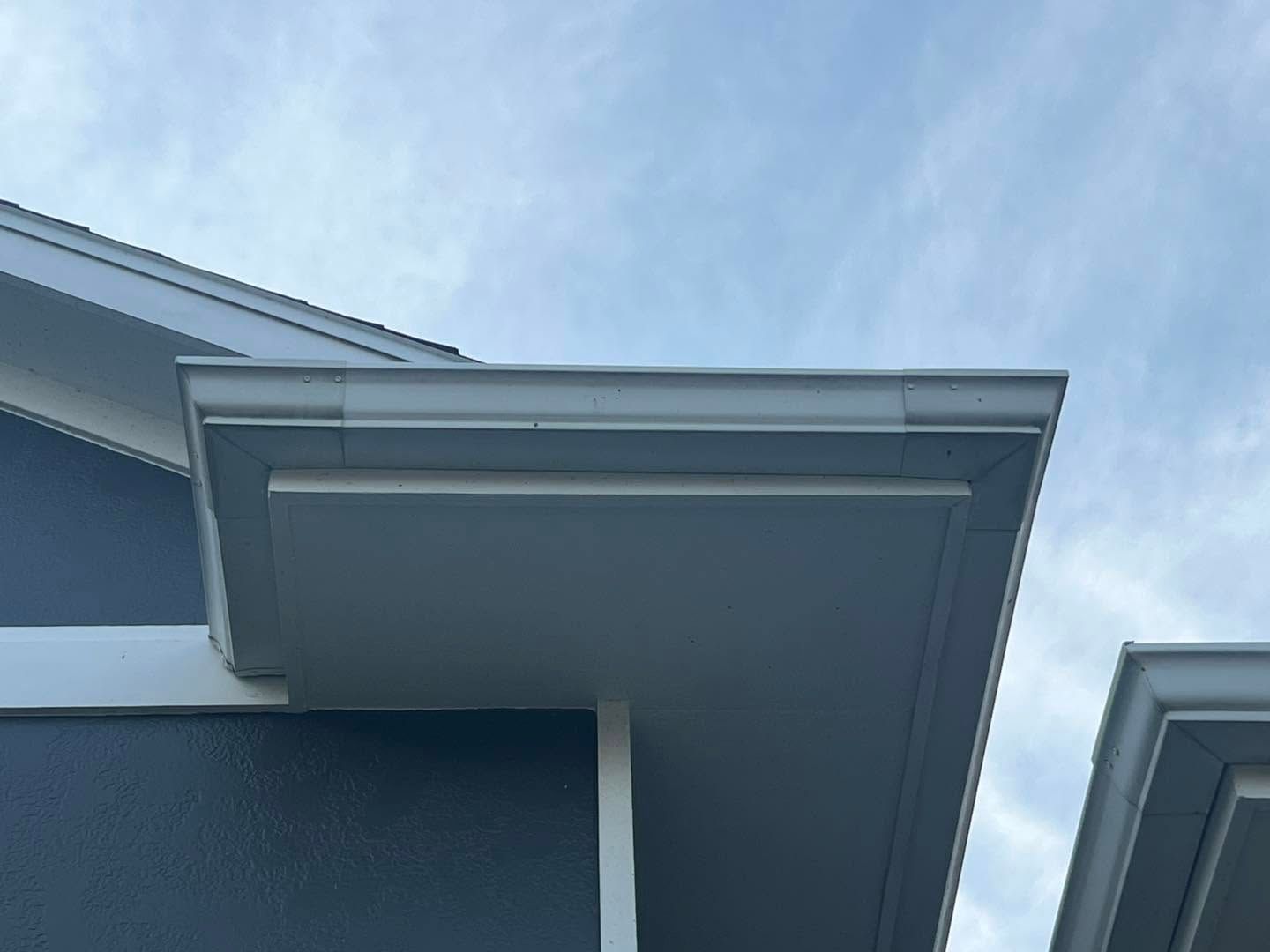 A close up of the roof of a house with a blue sky in the background.