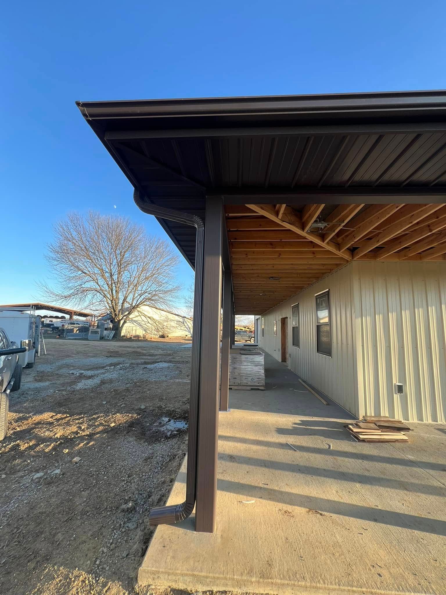 A house with a covered porch and a tree in the background.