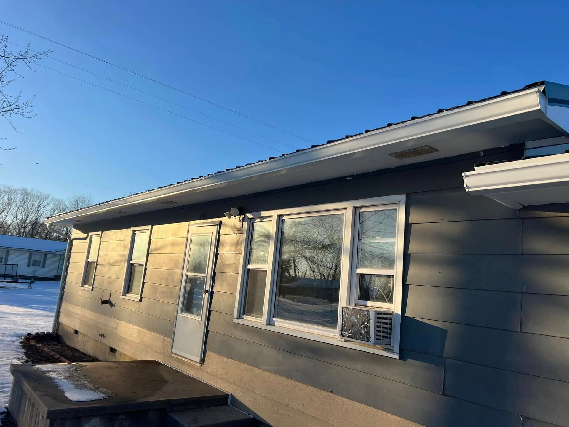A house with a lot of windows and a blue sky in the background.