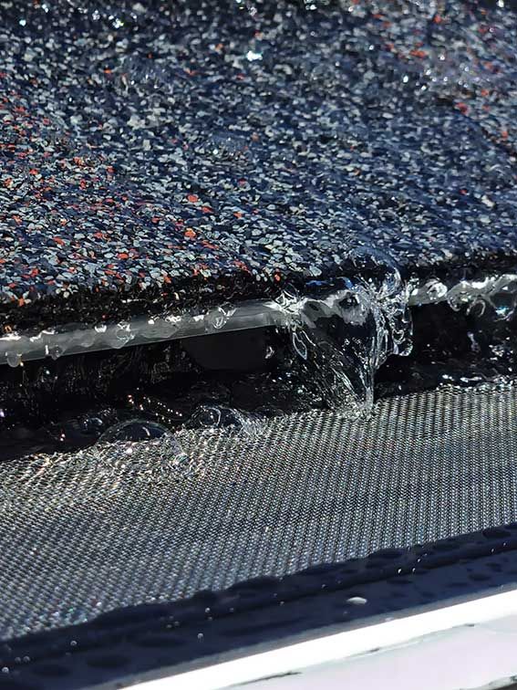 A close up of a roof with water coming out of it.