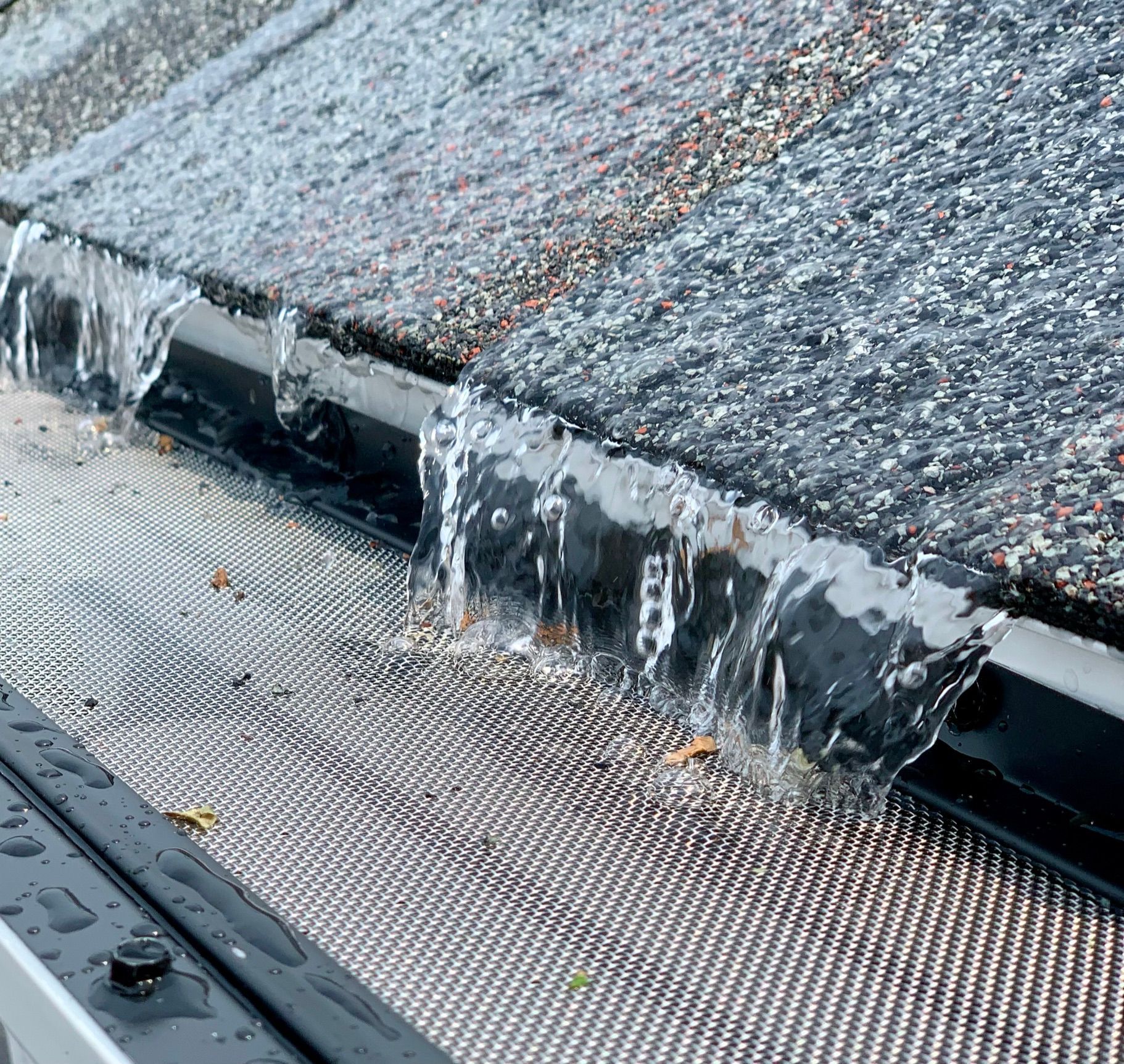 Water is running down a gutter on a roof.