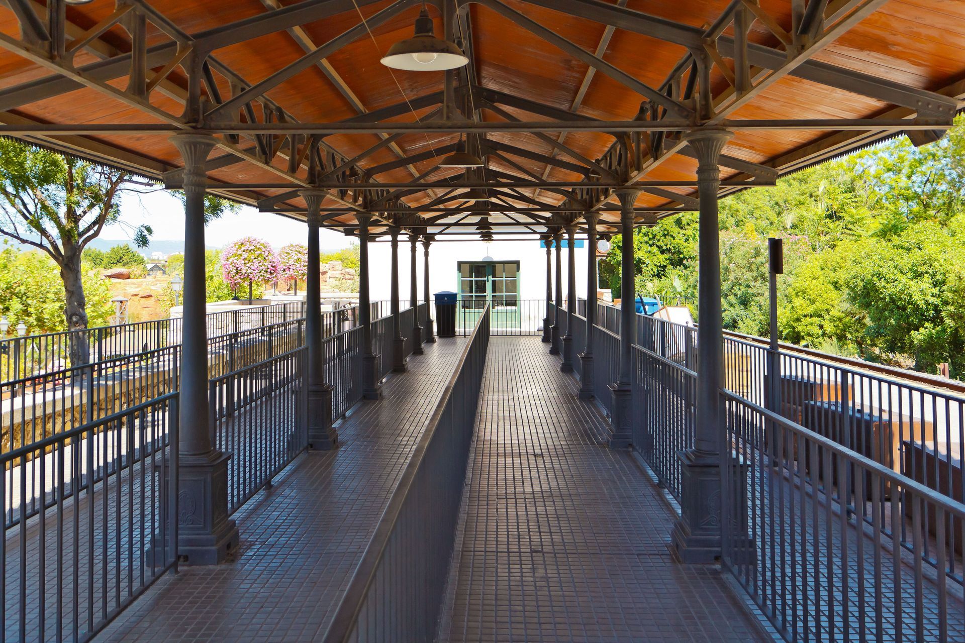 A long walkway with a wooden roof and a metal railing.