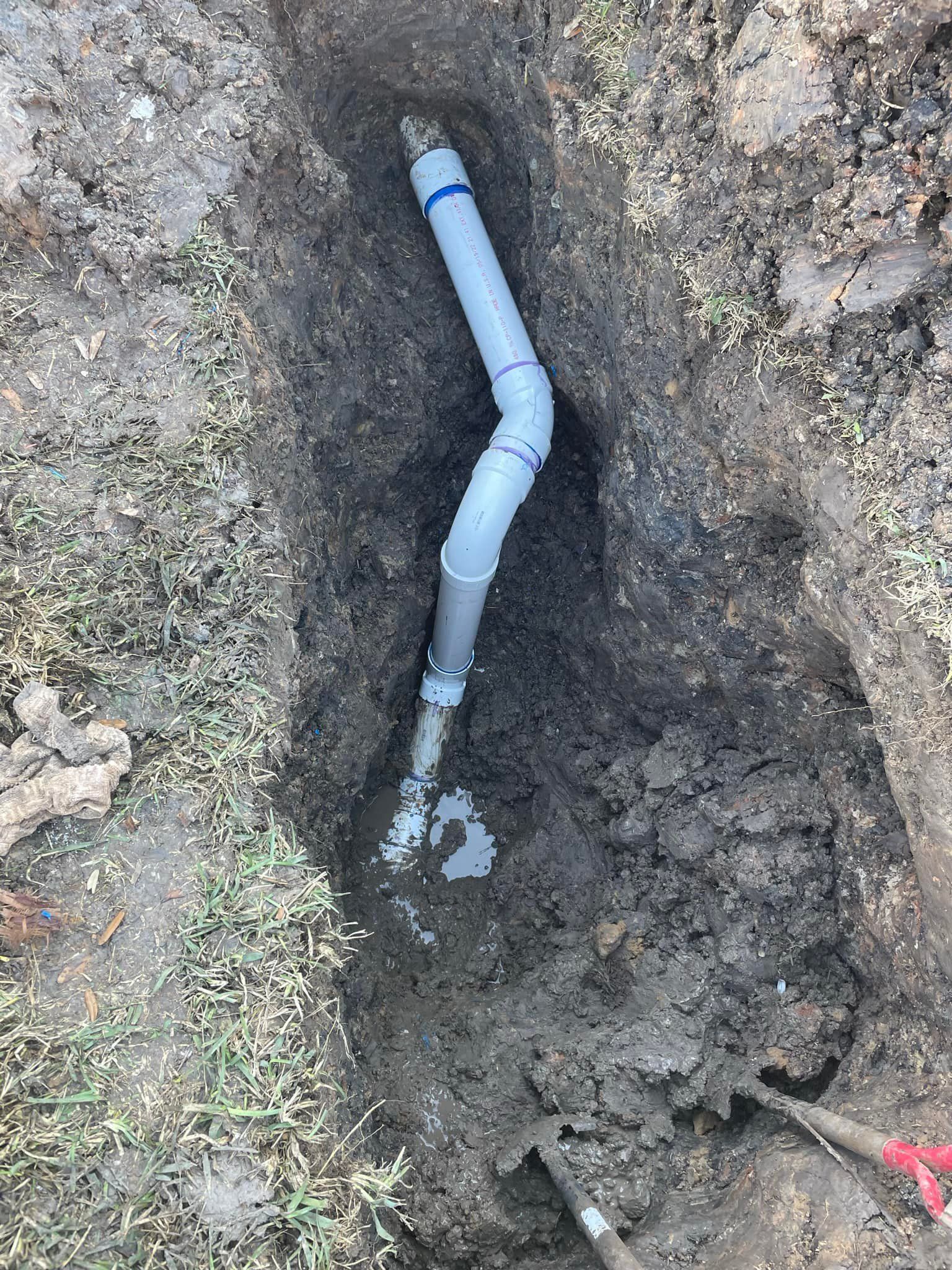 A pipe is being installed in a hole in the ground.
