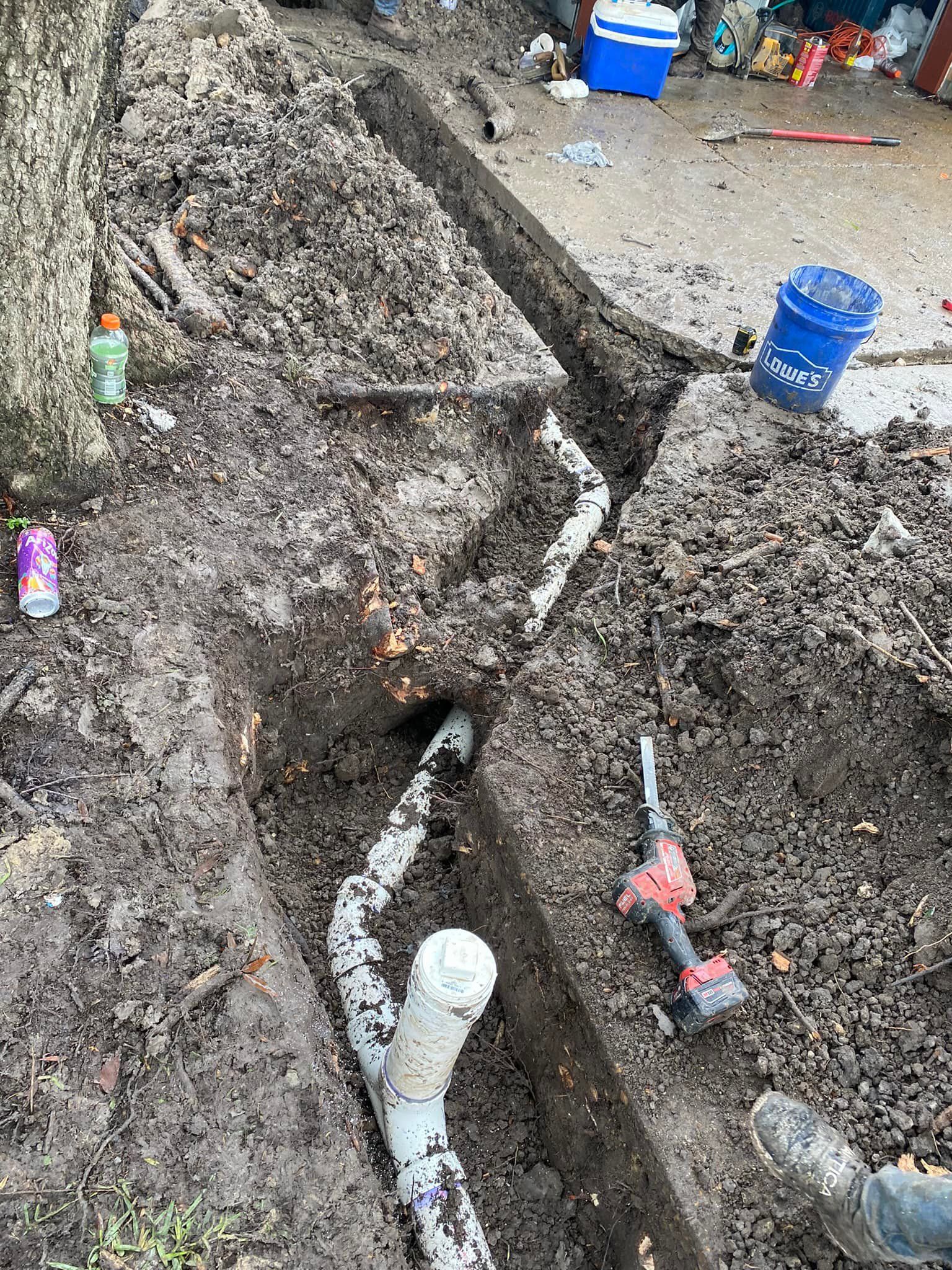 A drain pipe is being installed in a hole in the ground.