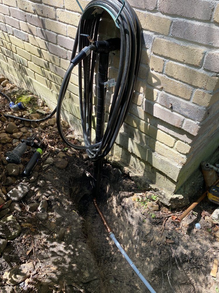 A hose is hanging on a brick wall next to a brick wall.