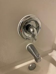 A close up of a bathtub faucet in a bathroom.