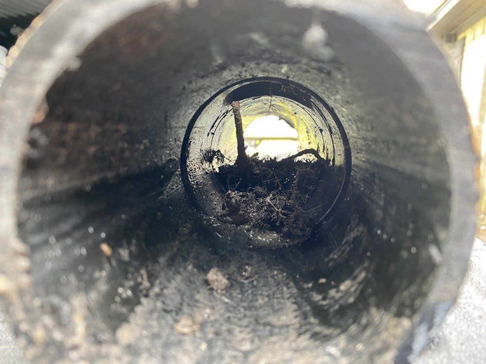 A close up of a dirty pipe with a hole in the middle.