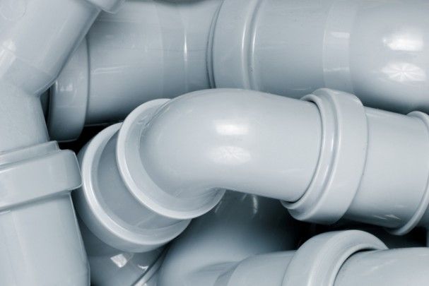 A bunch of white plastic pipes are stacked on top of each other.