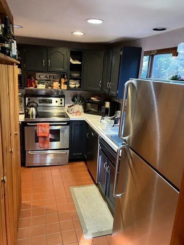 A kitchen with stainless steel appliances and black cabinets