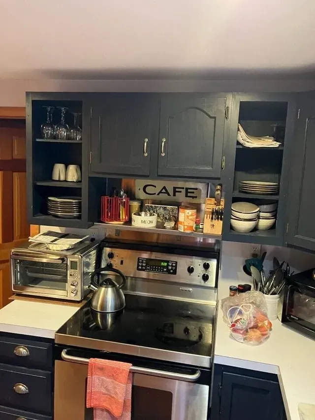 A kitchen with a stove , oven , microwave and a sign that says cafe.
