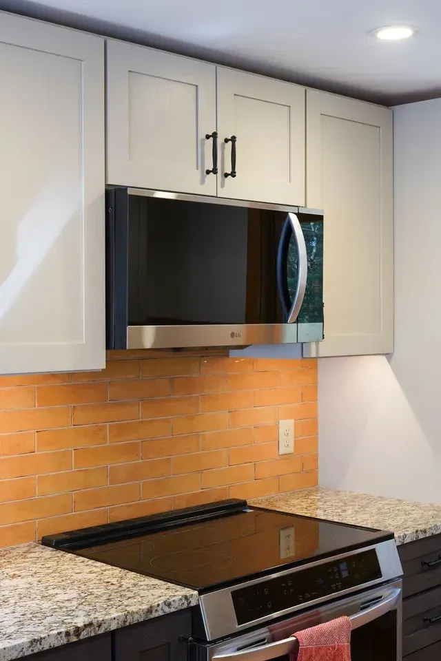 A kitchen with a stove top oven and a microwave