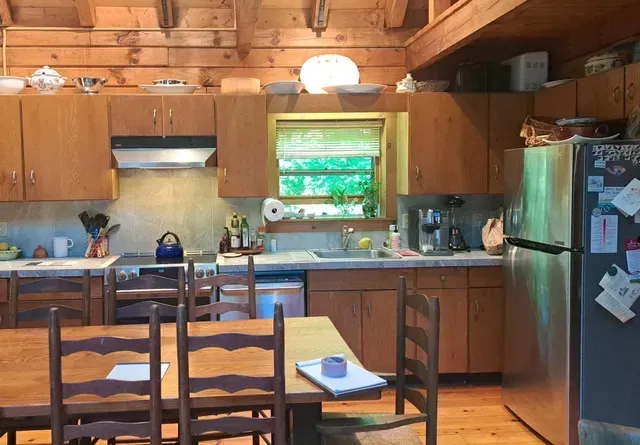 A kitchen with wooden cabinets and a stainless steel refrigerator