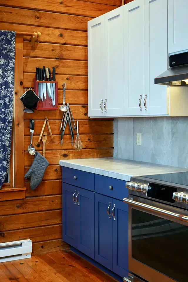A kitchen with blue cabinets and stainless steel appliances