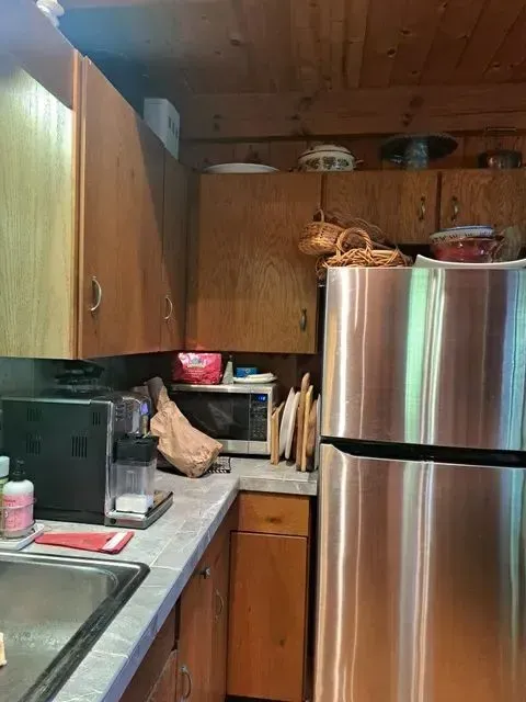 A kitchen with a stainless steel refrigerator and a sink