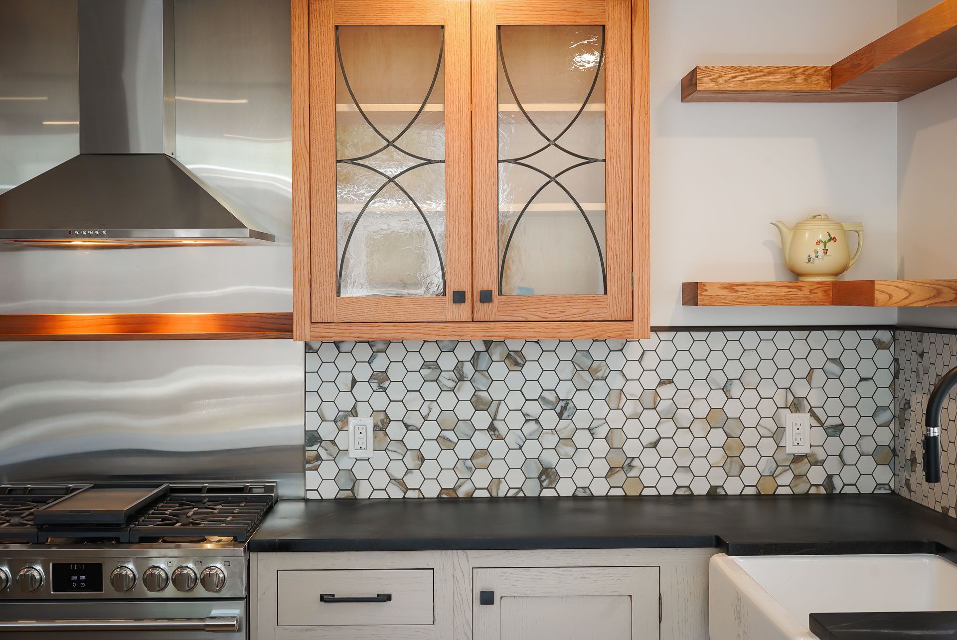 A kitchen with a stove , sink , and cabinets.
