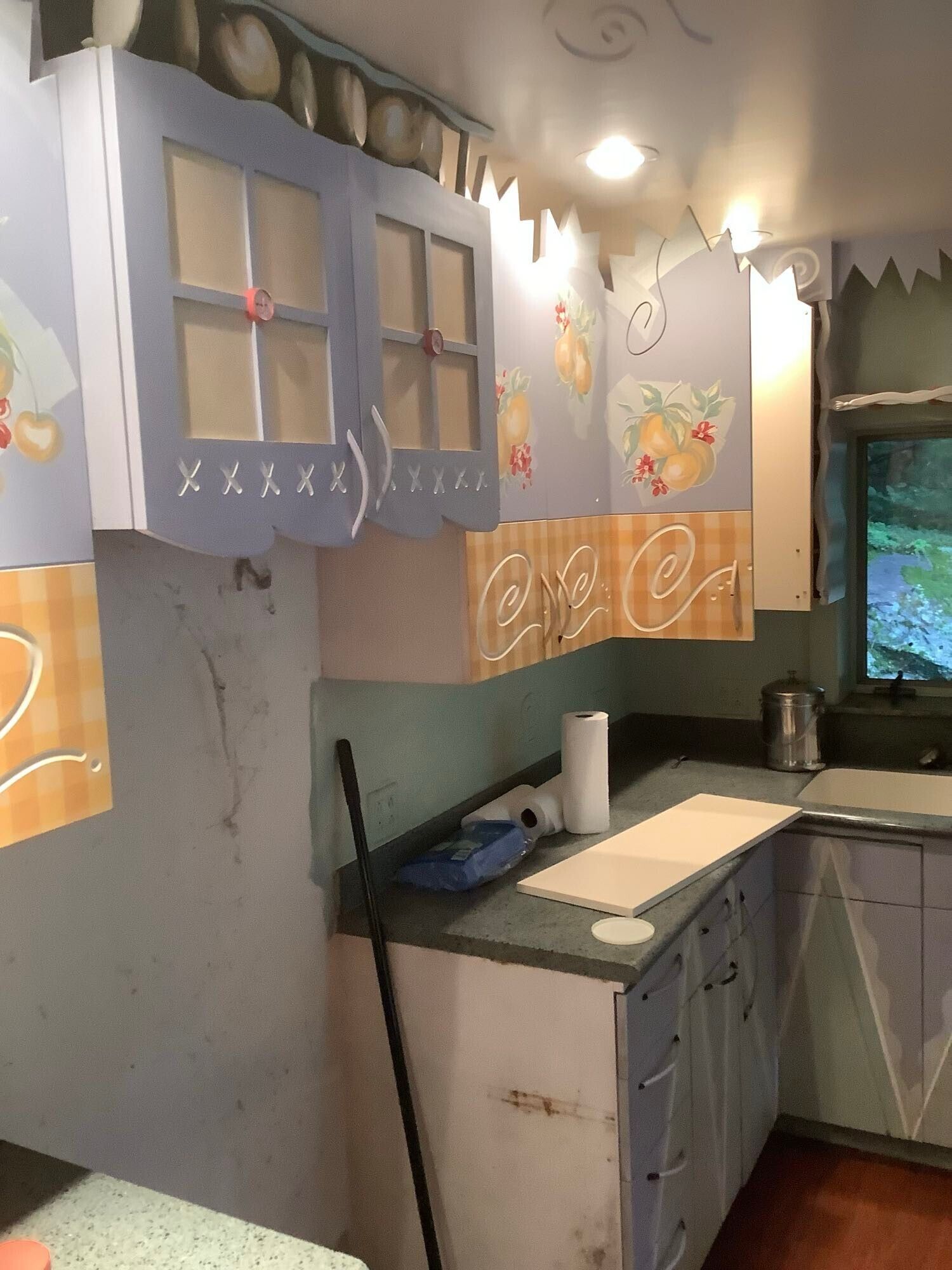 A kitchen with blue cabinets and a mop on the counter