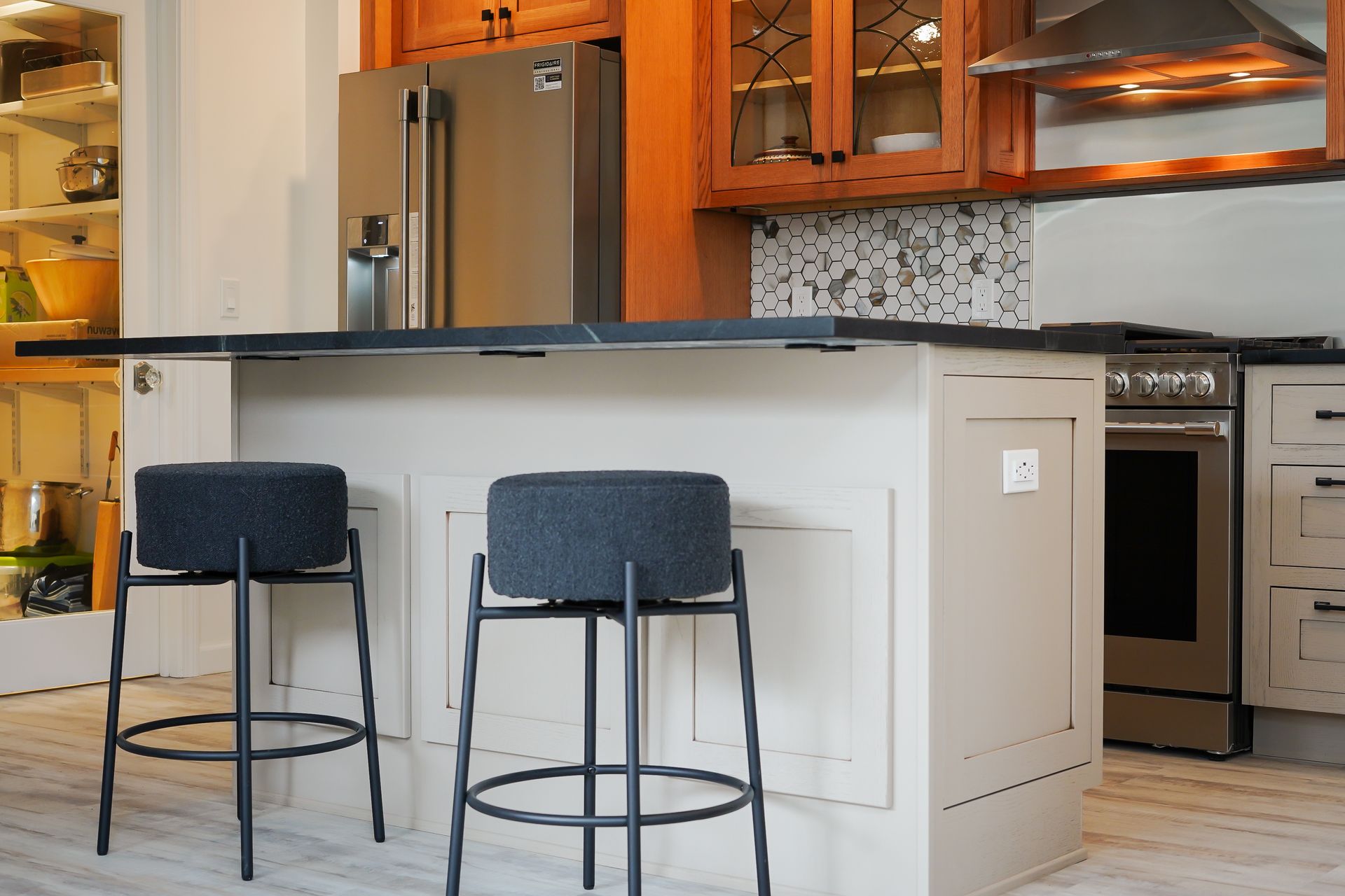 A kitchen with a large island and three bar stools