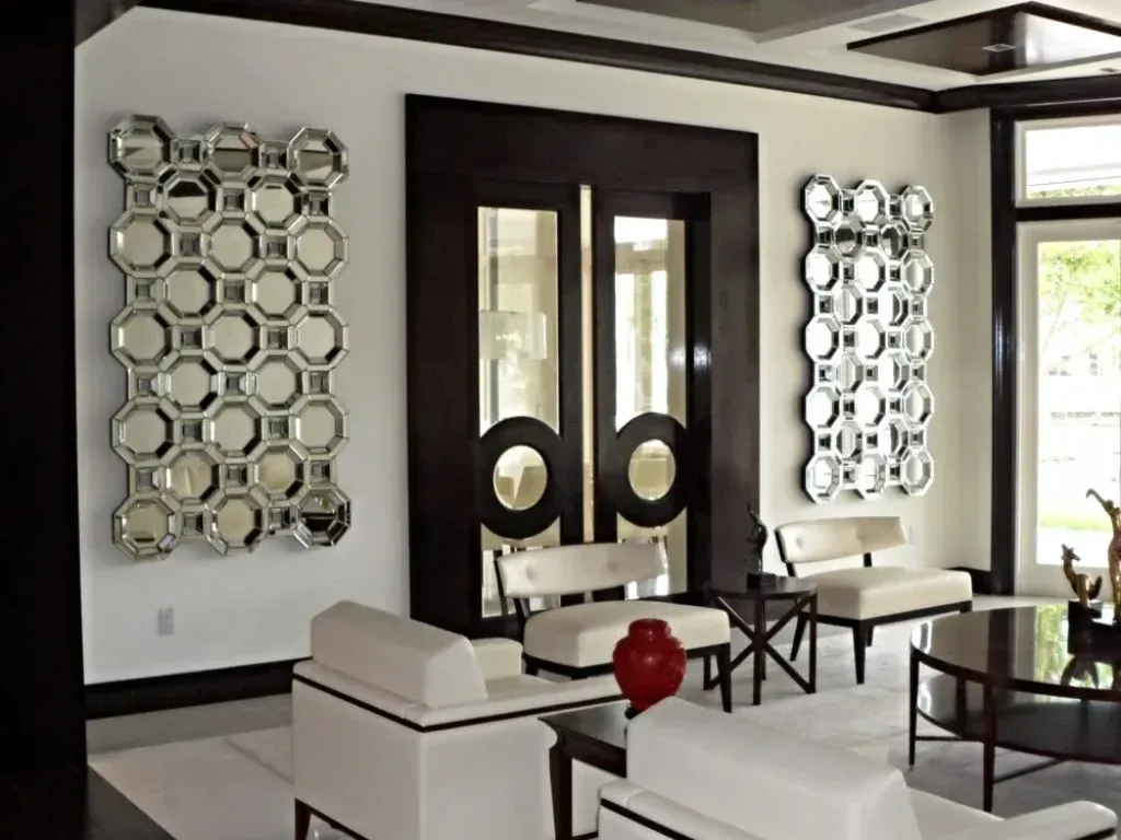 A living room with white furniture and mirrors on the wall