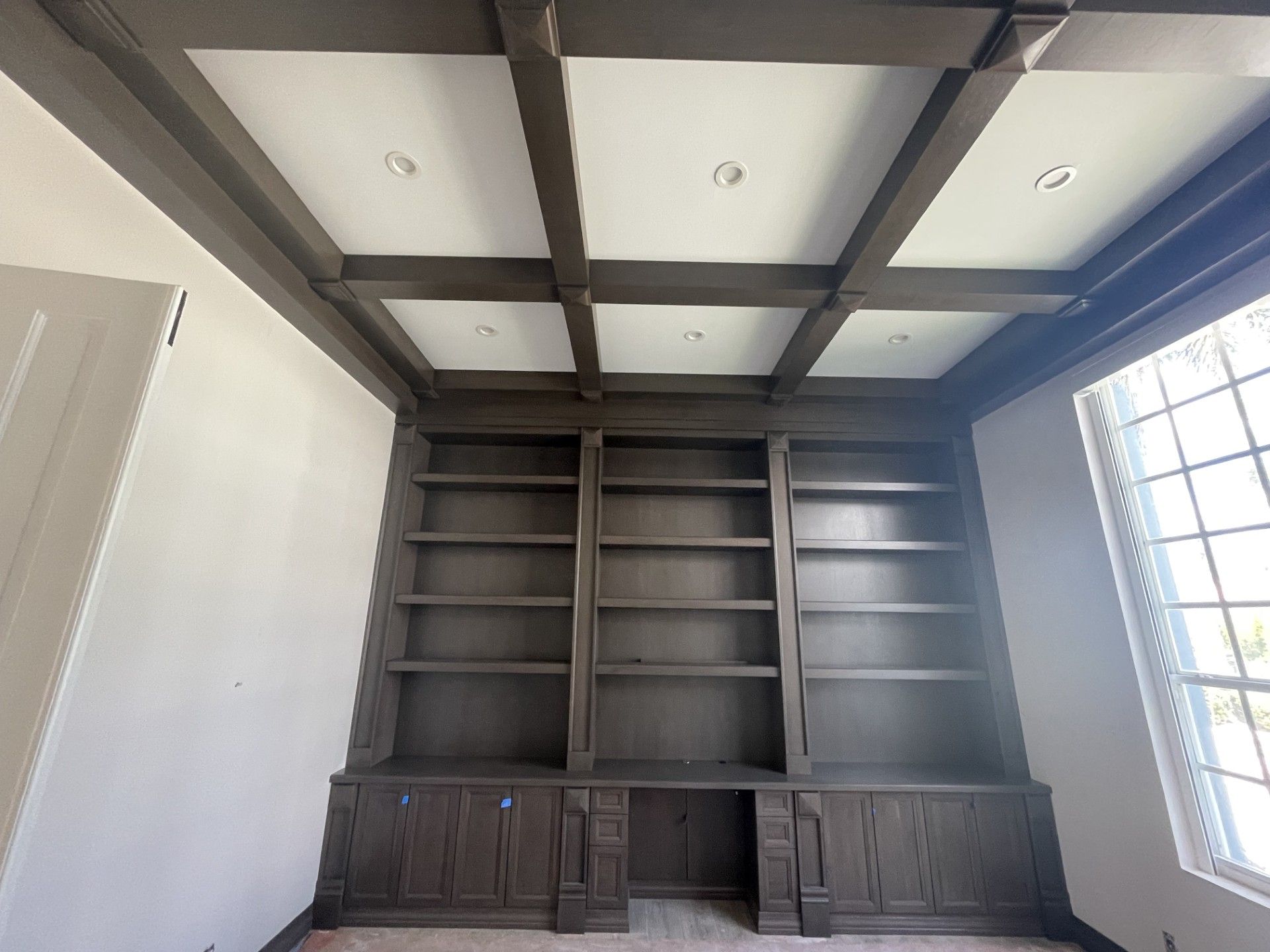 A room with lots of shelves and a coffered ceiling