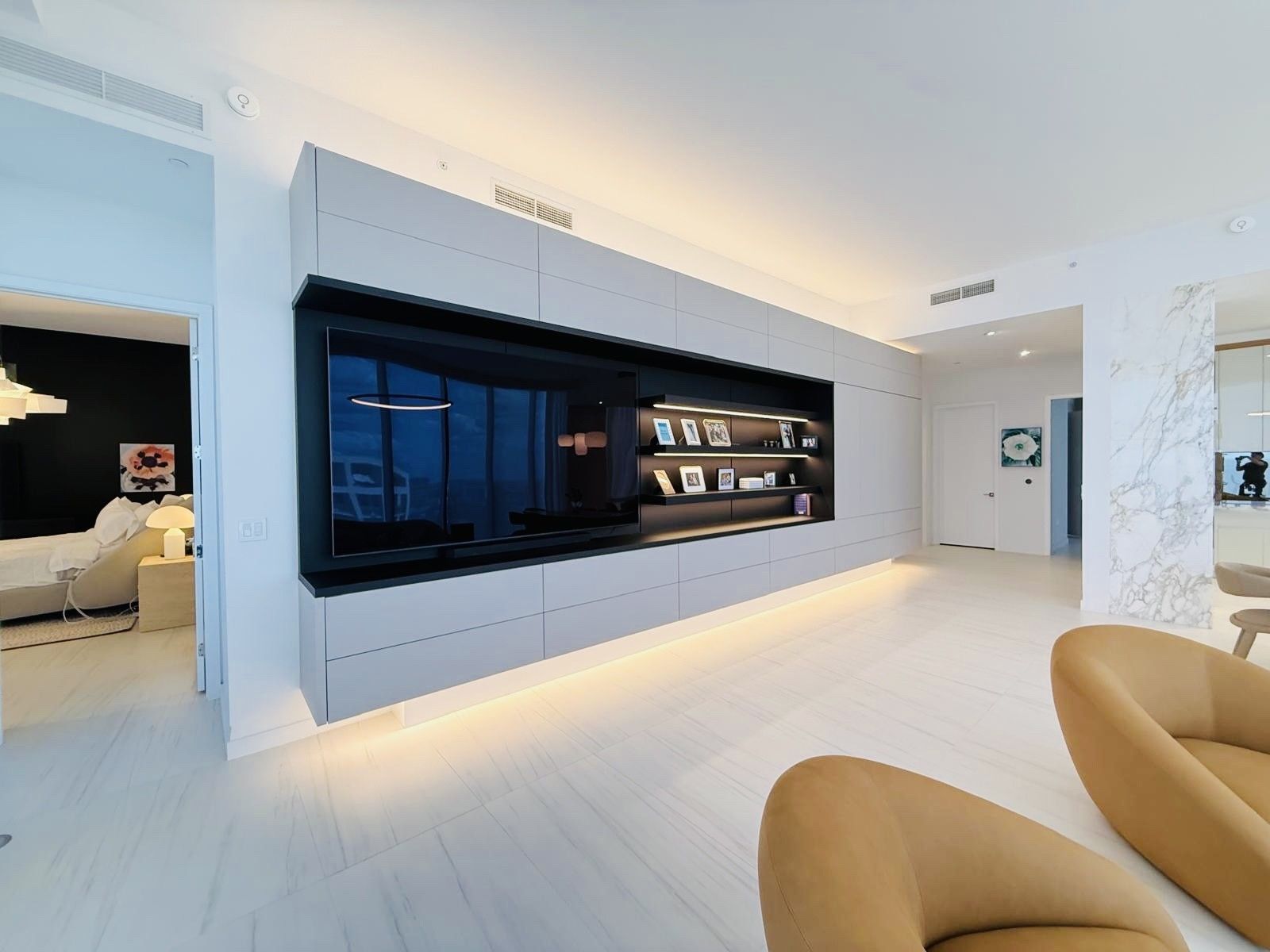 A living room with a large flat screen tv on the wall.