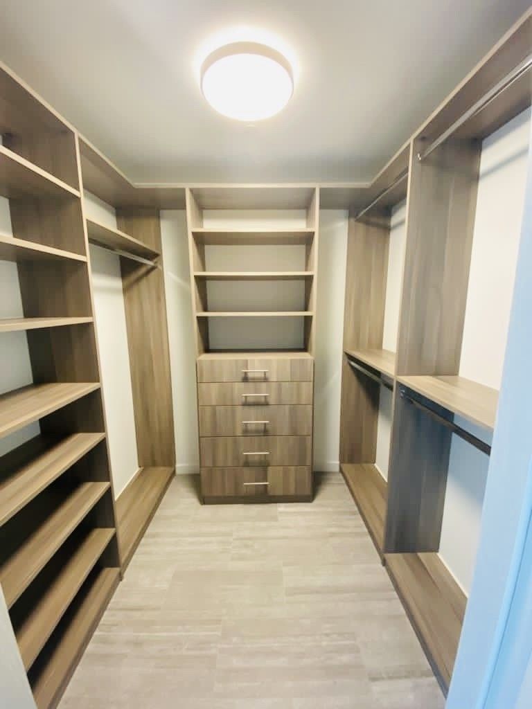 A walk in closet with lots of shelves and drawers.