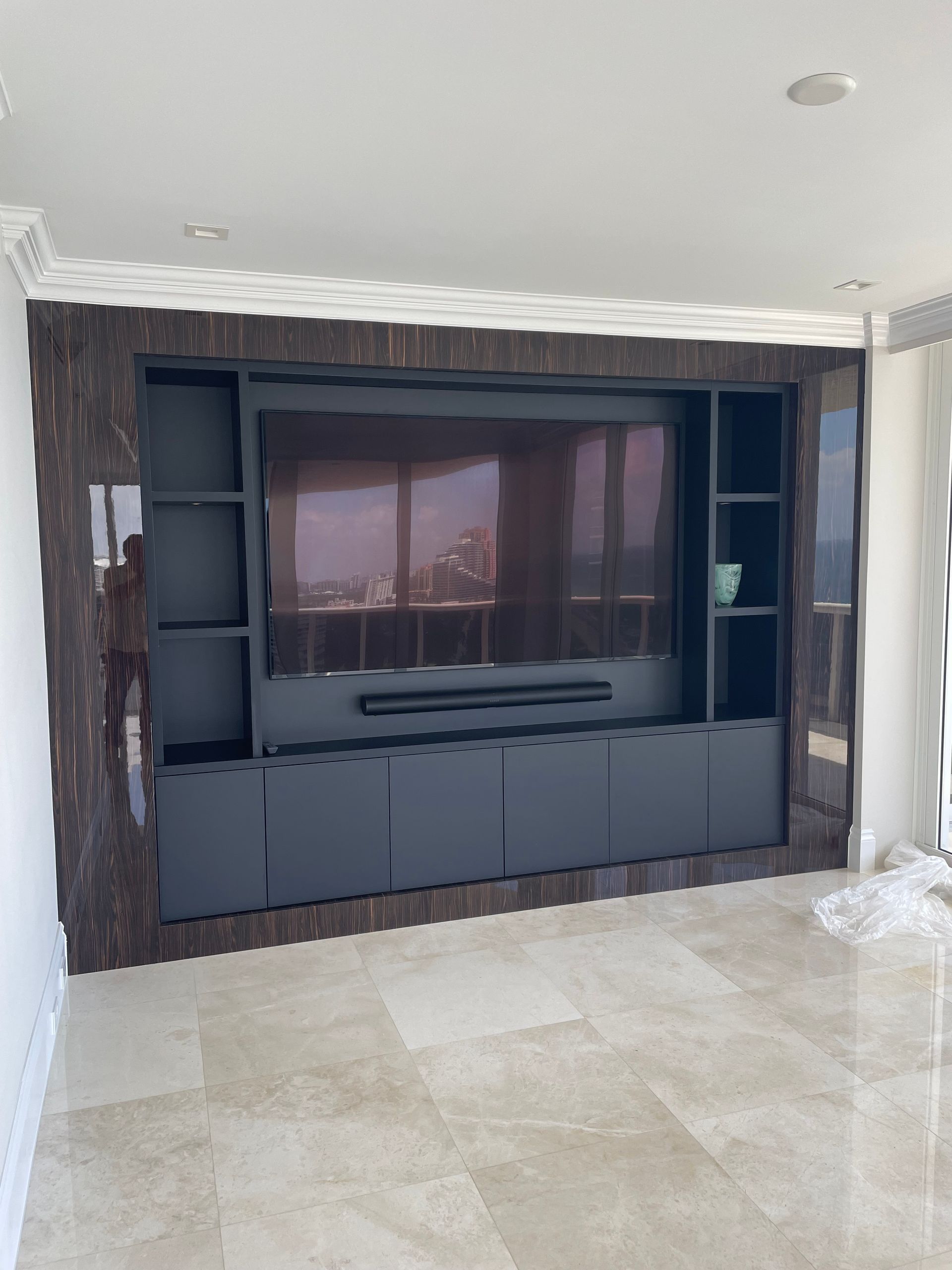 A living room with a large flat screen tv and shelves