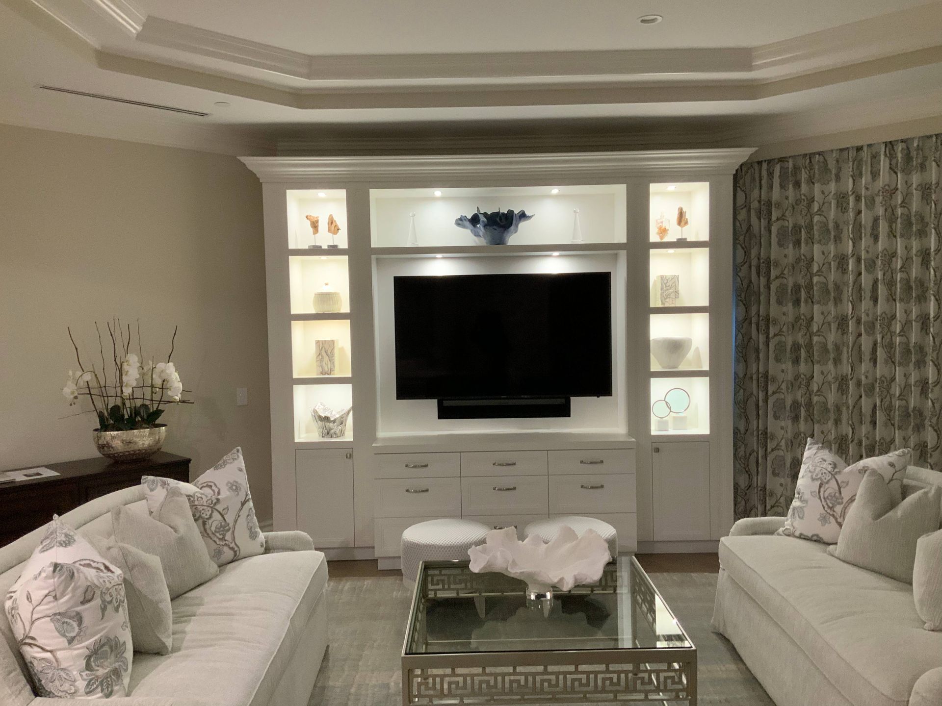 A living room with two couches , a coffee table and a flat screen tv.