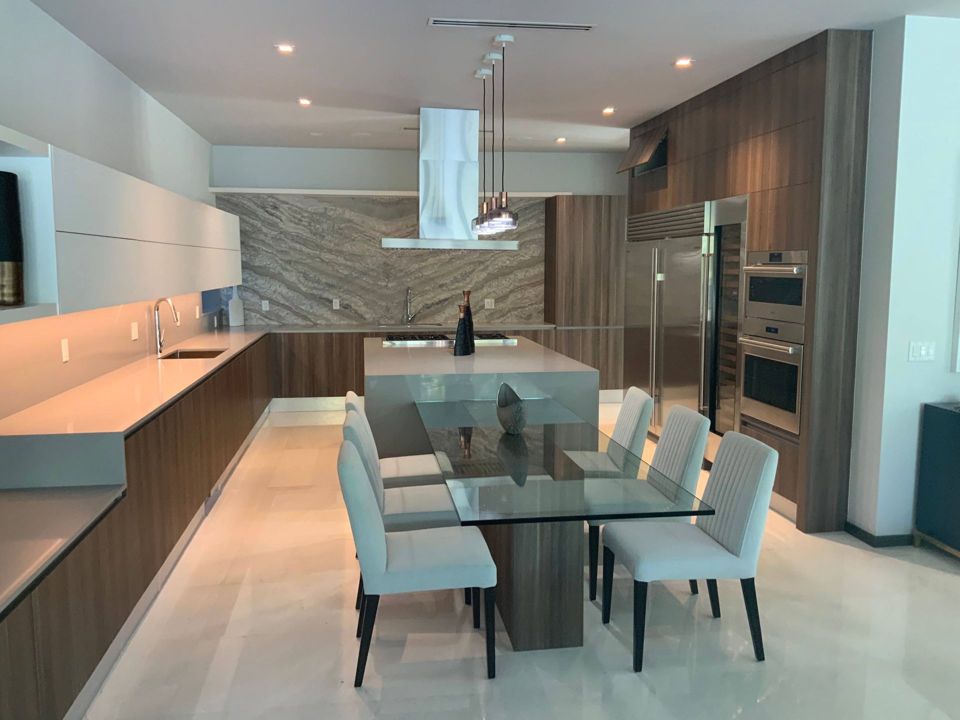 A kitchen with a glass table and chairs in it