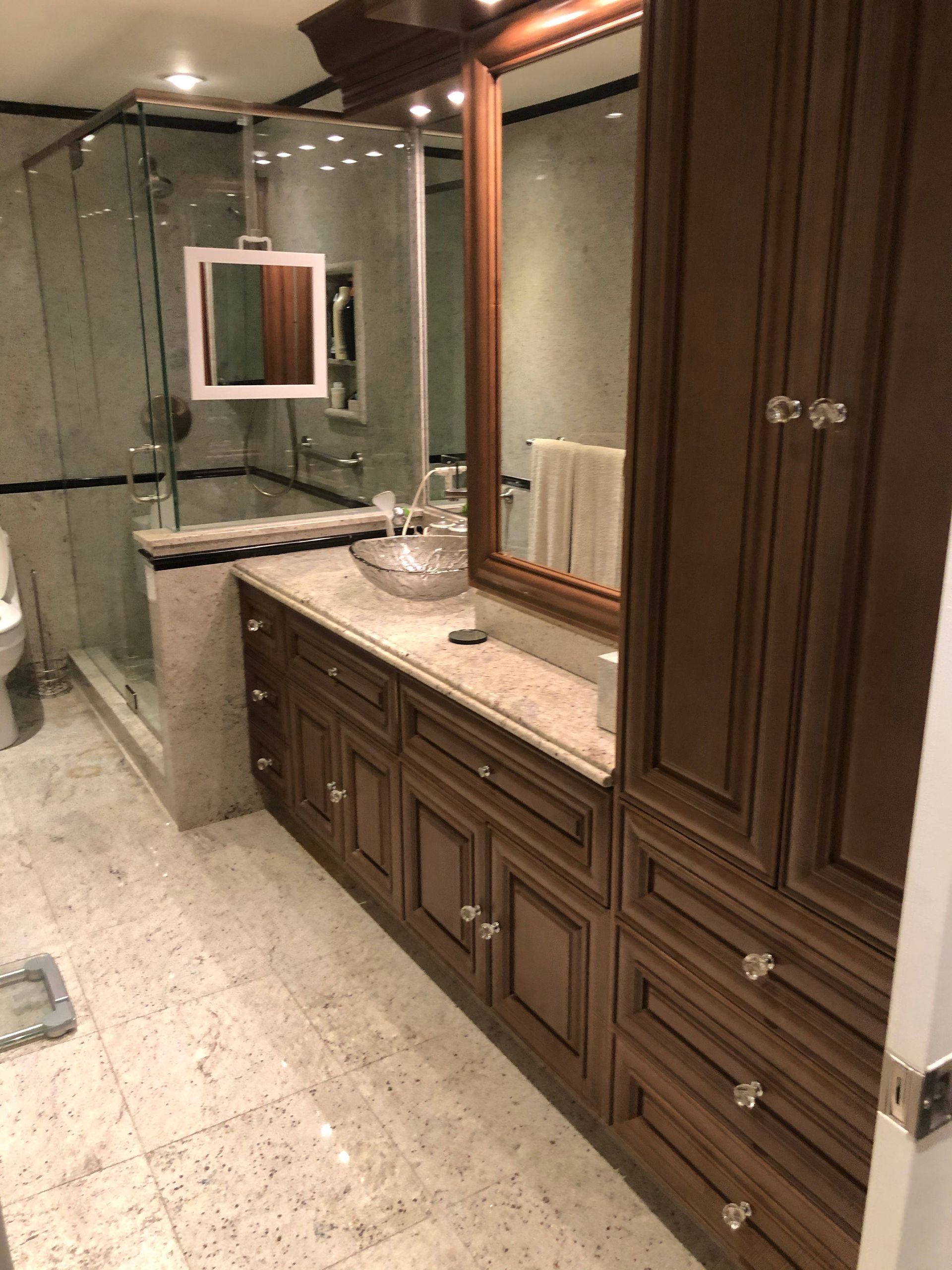 A bathroom with a sink , mirror and cabinets