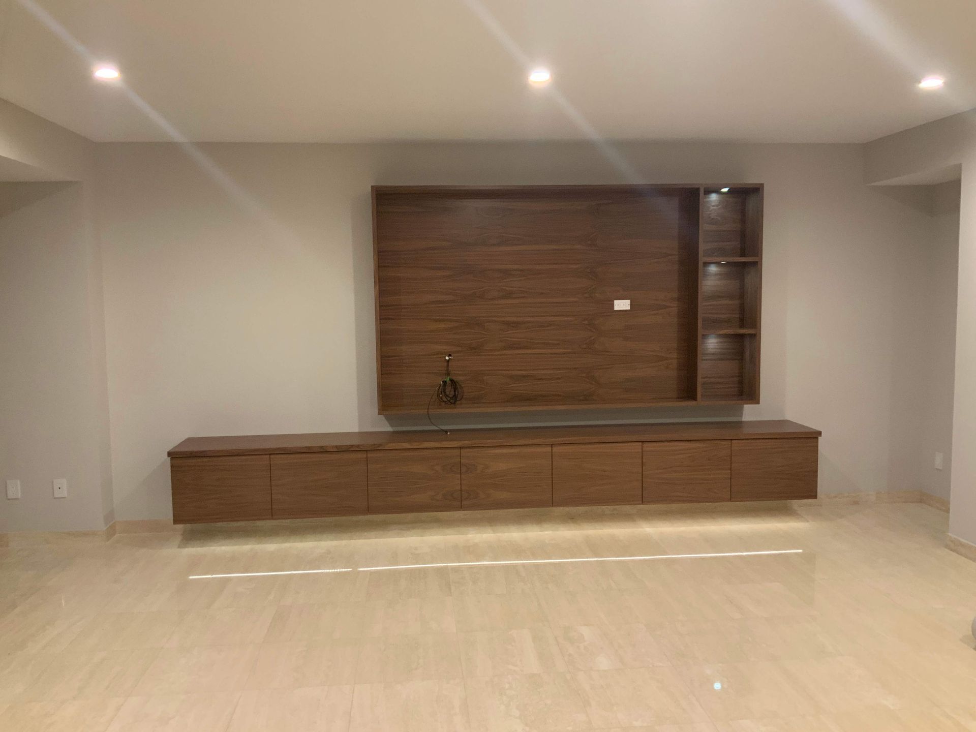 A living room with a wooden entertainment center and a wooden wall.