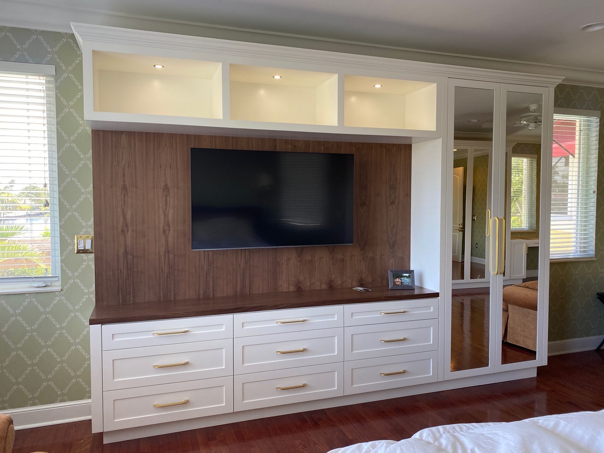 A bedroom with a large flat screen tv on the wall.