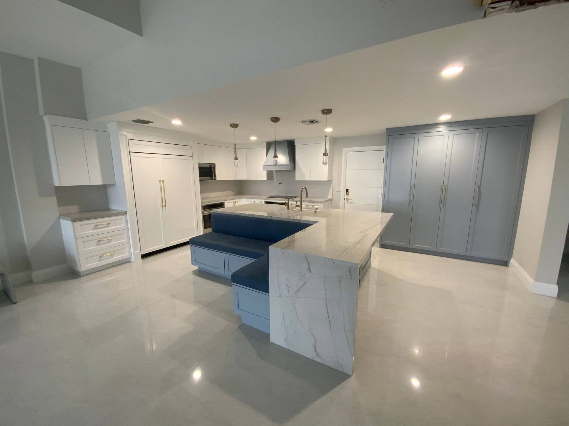 A kitchen with a large island and a couch in the middle of it.