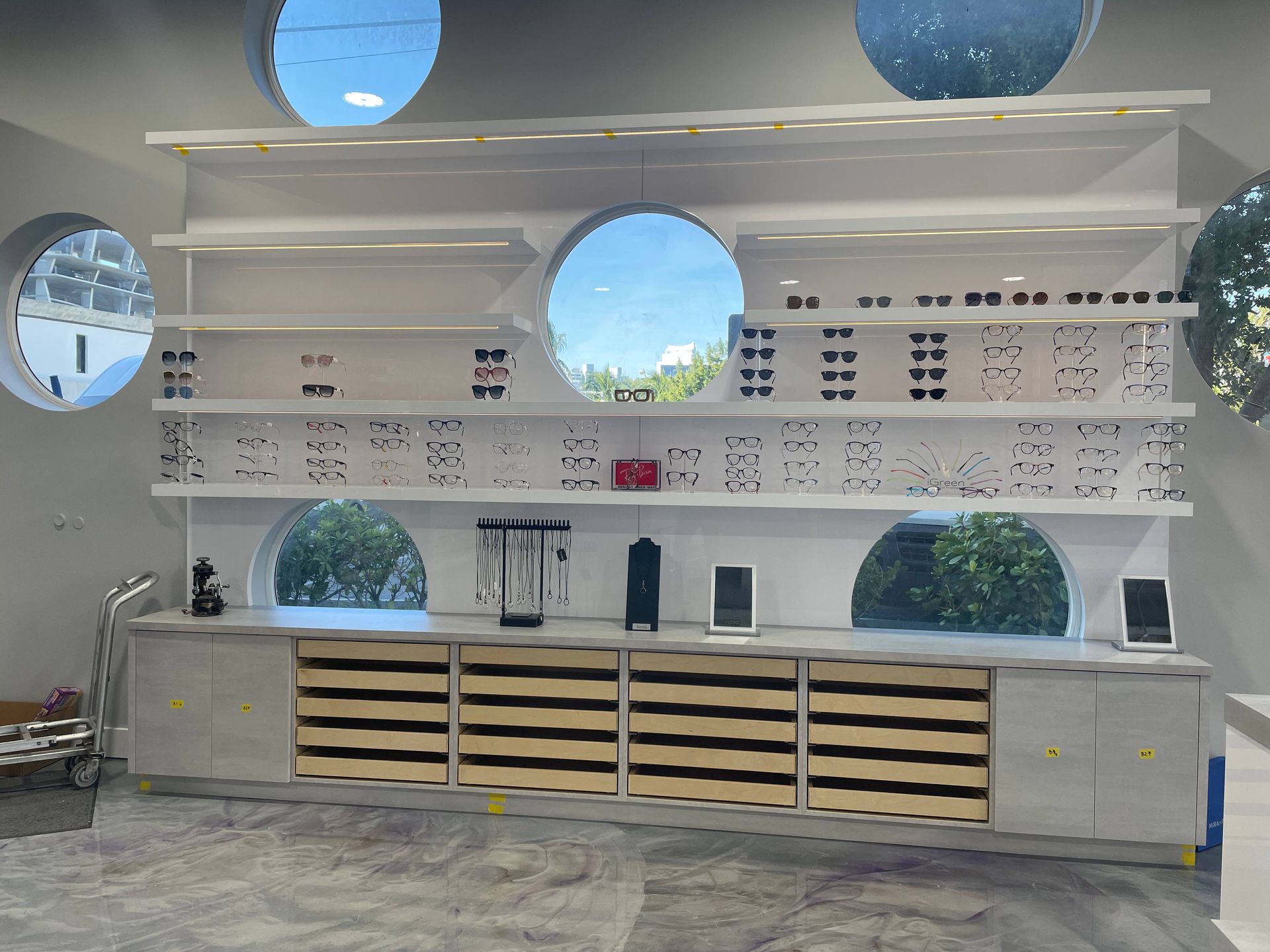 A room with a lot of shelves and a lot of windows.