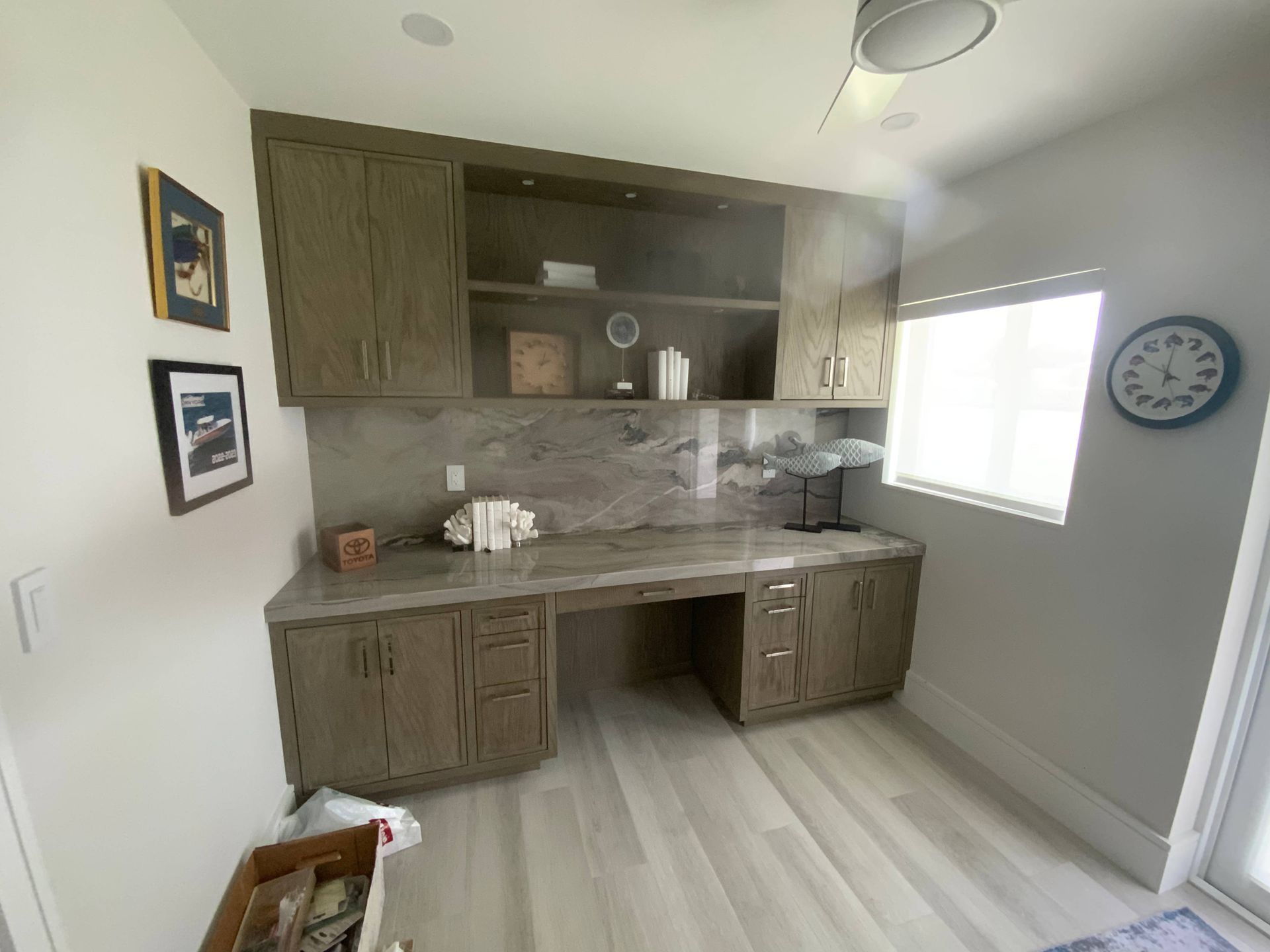 A room with a desk and a clock on the wall.