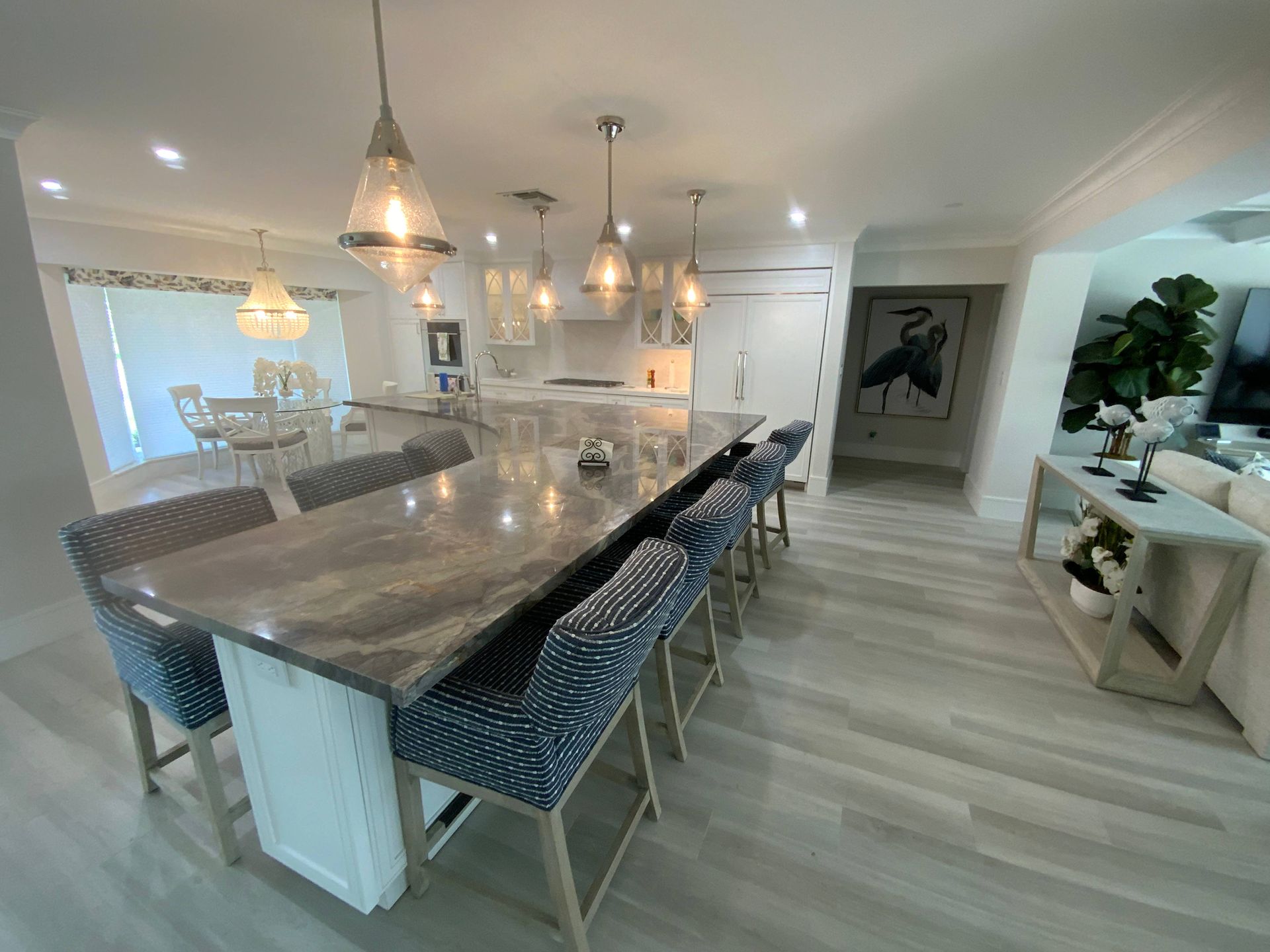 A kitchen with a long table and chairs in it.
