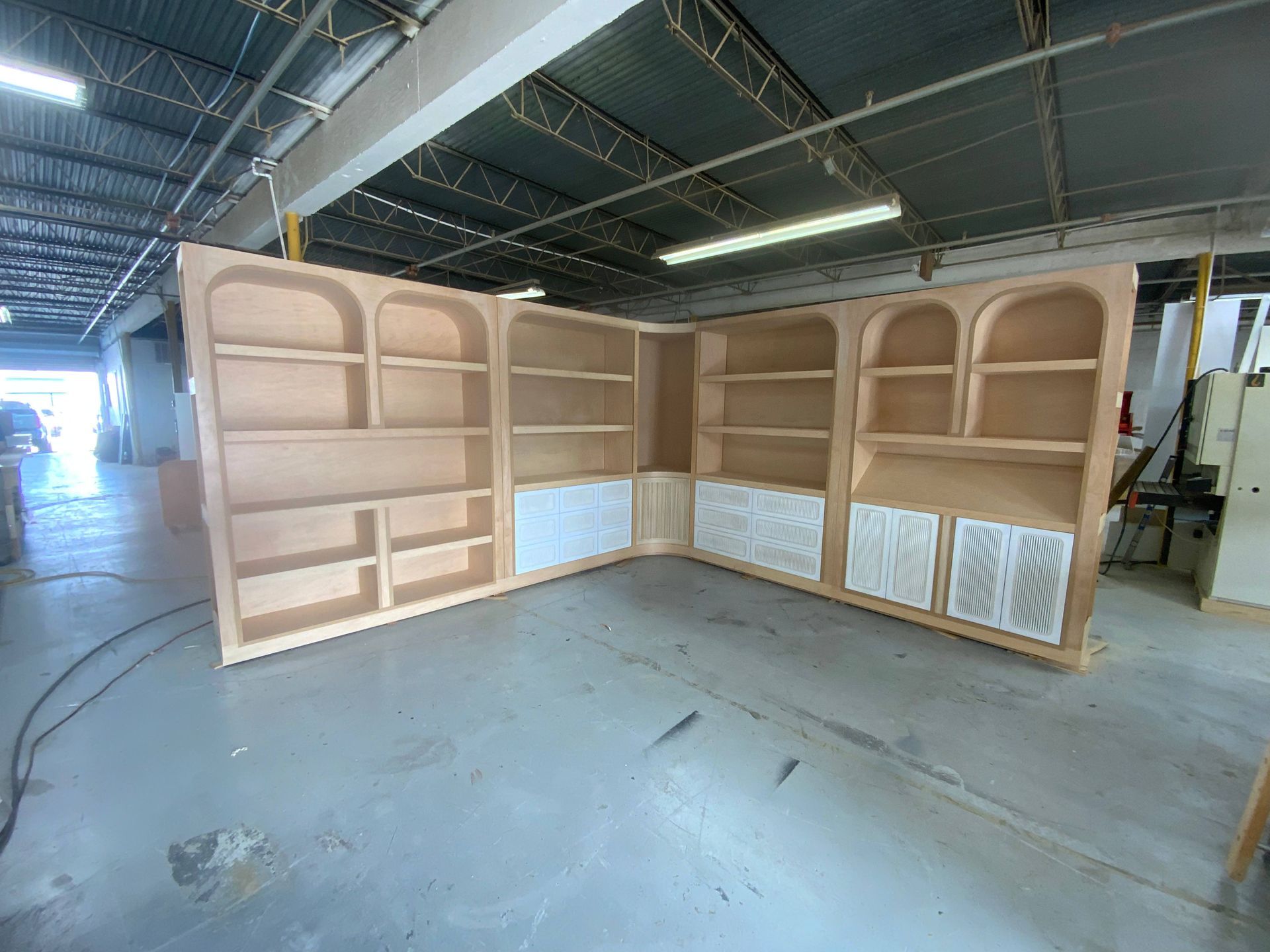 A large wooden shelving unit is being built in a factory.