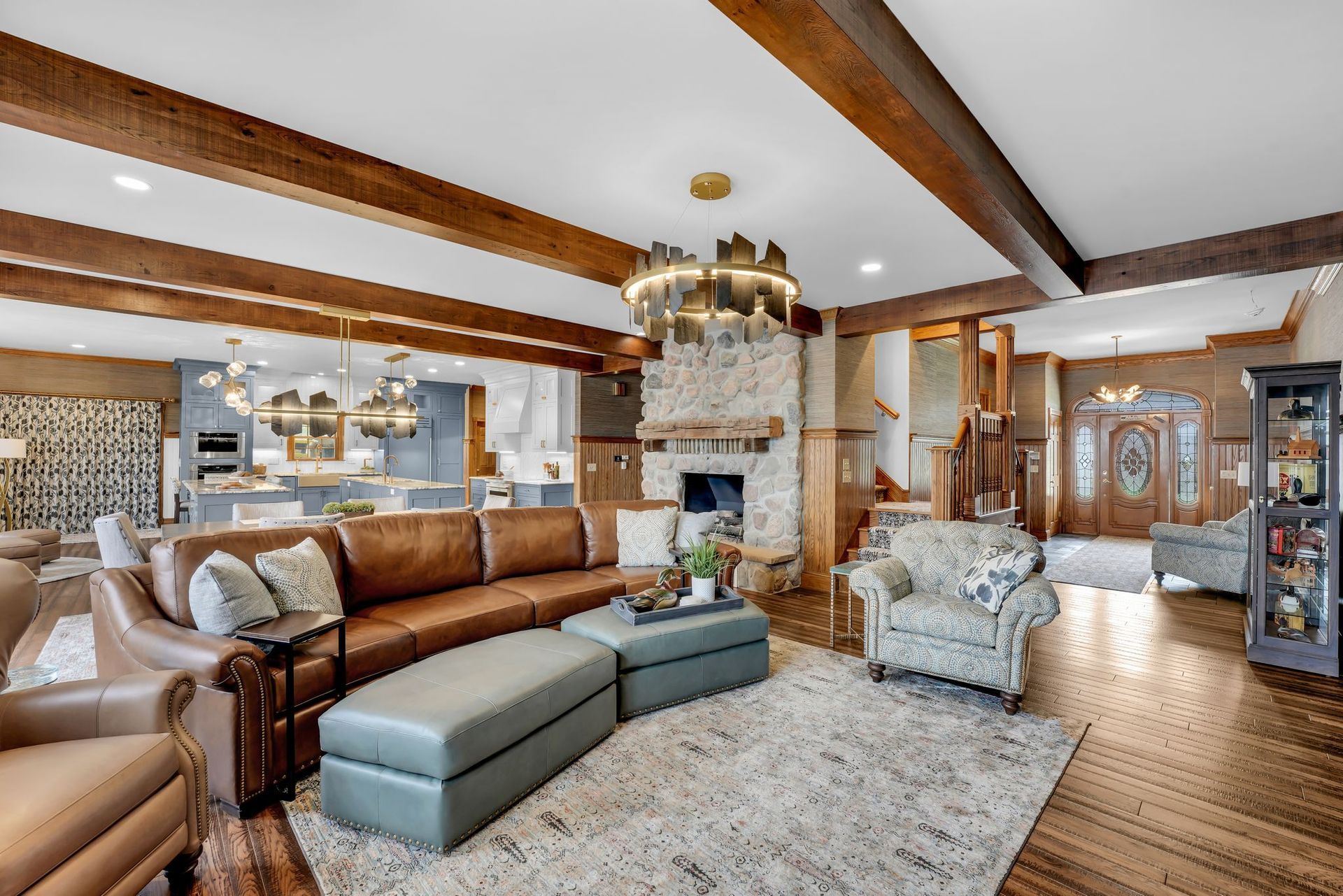 Spacious living room with leather furniture, fireplace, and open kitchen view.