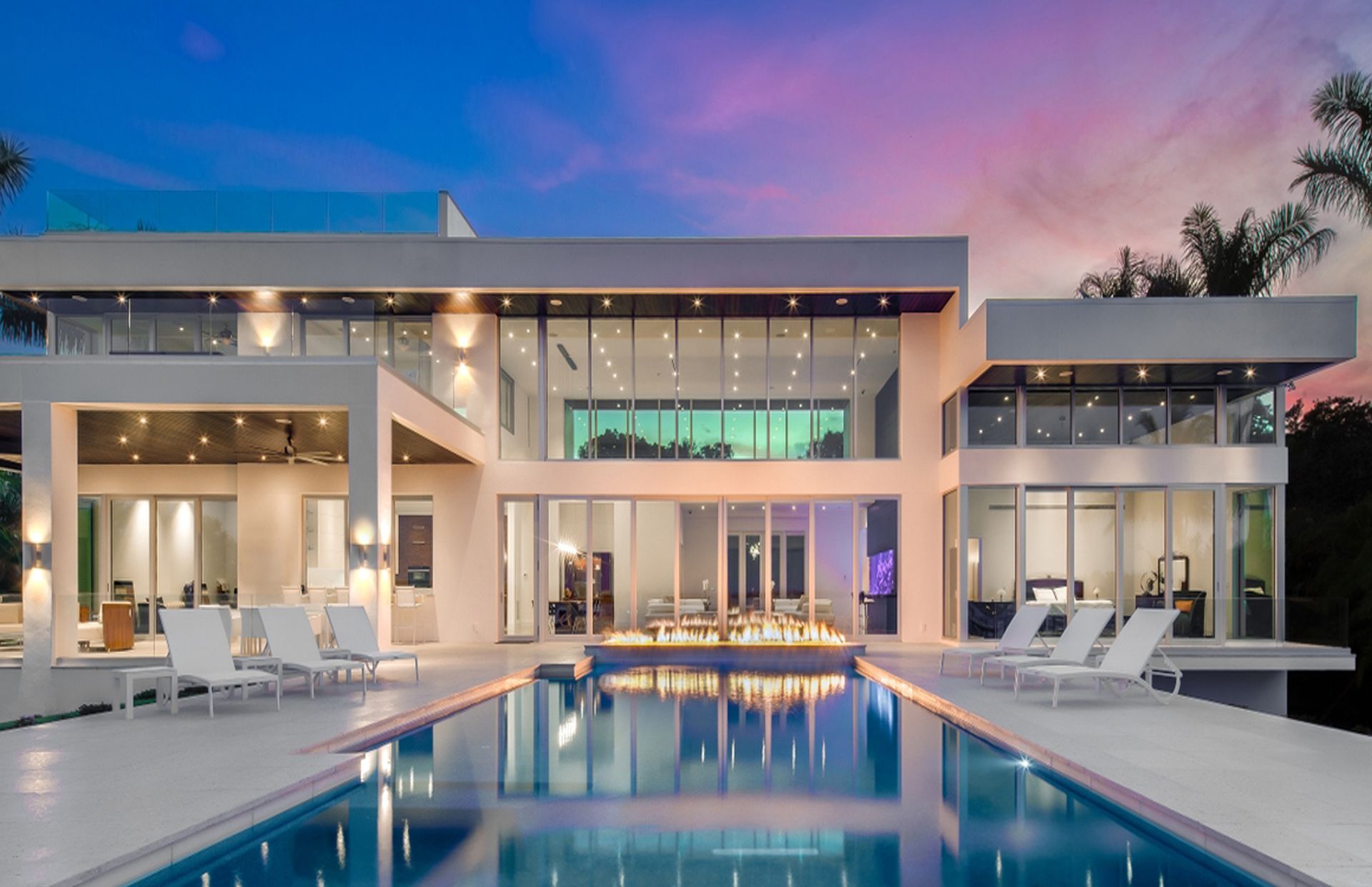 A large house with a swimming pool in front of it