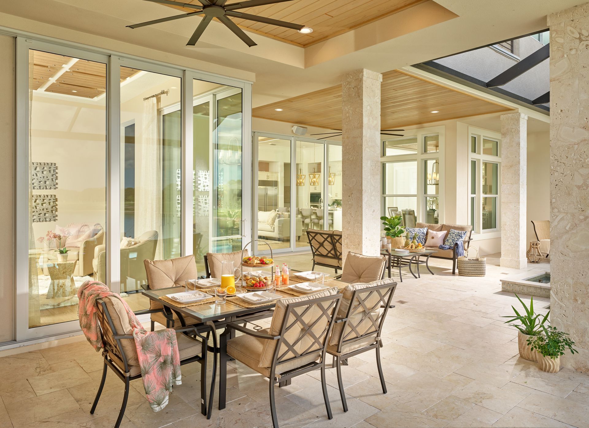 A patio with a table and chairs and a ceiling fan.