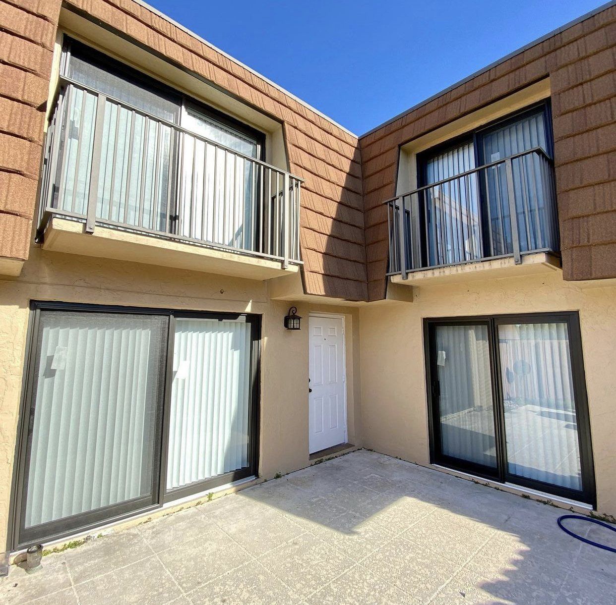 A building with a balcony and sliding glass doors