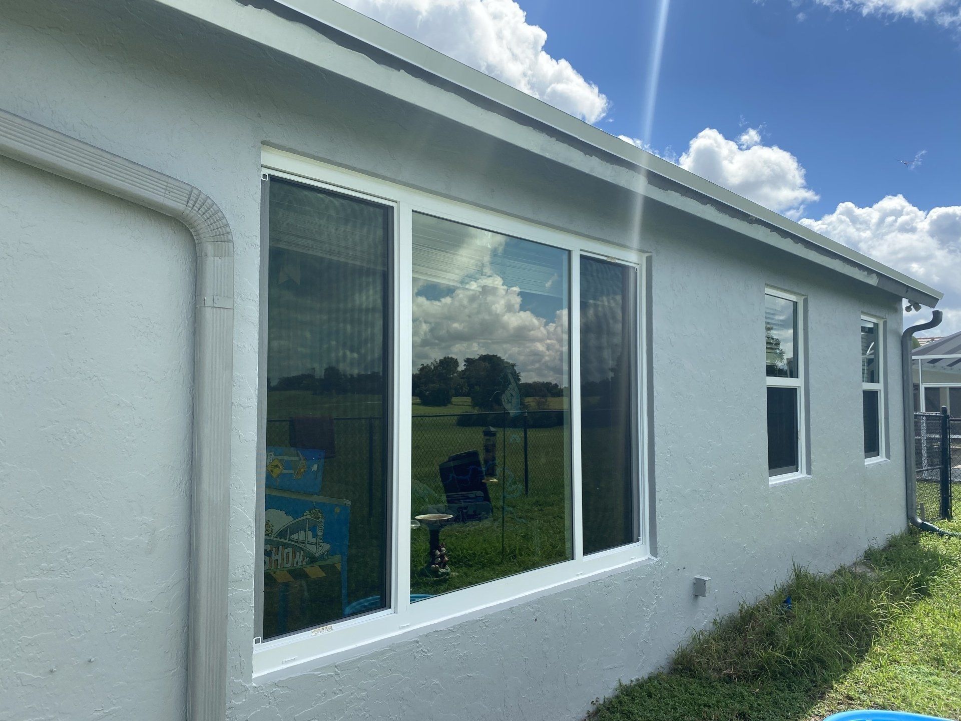 A white house with a large window on the side of it.