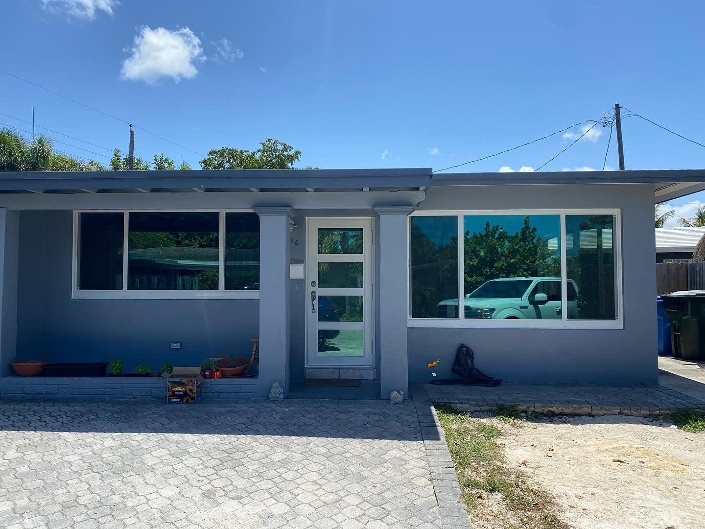 A house with a lot of windows and a car parked in front of it.