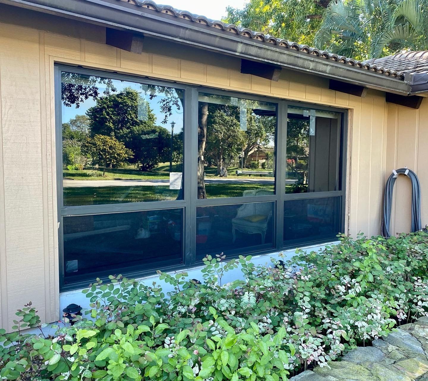 A house with a lot of windows and a hose in front of it