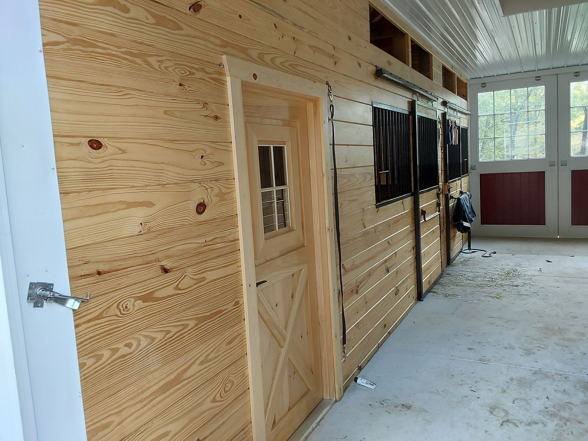 A row of wooden doors and windows in a barn.