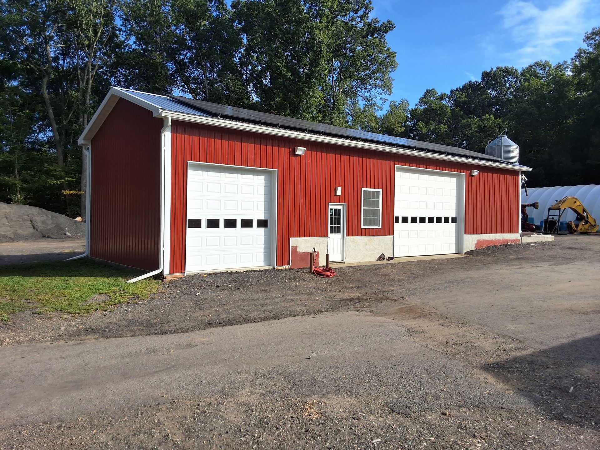 A large red barn with white garage doors