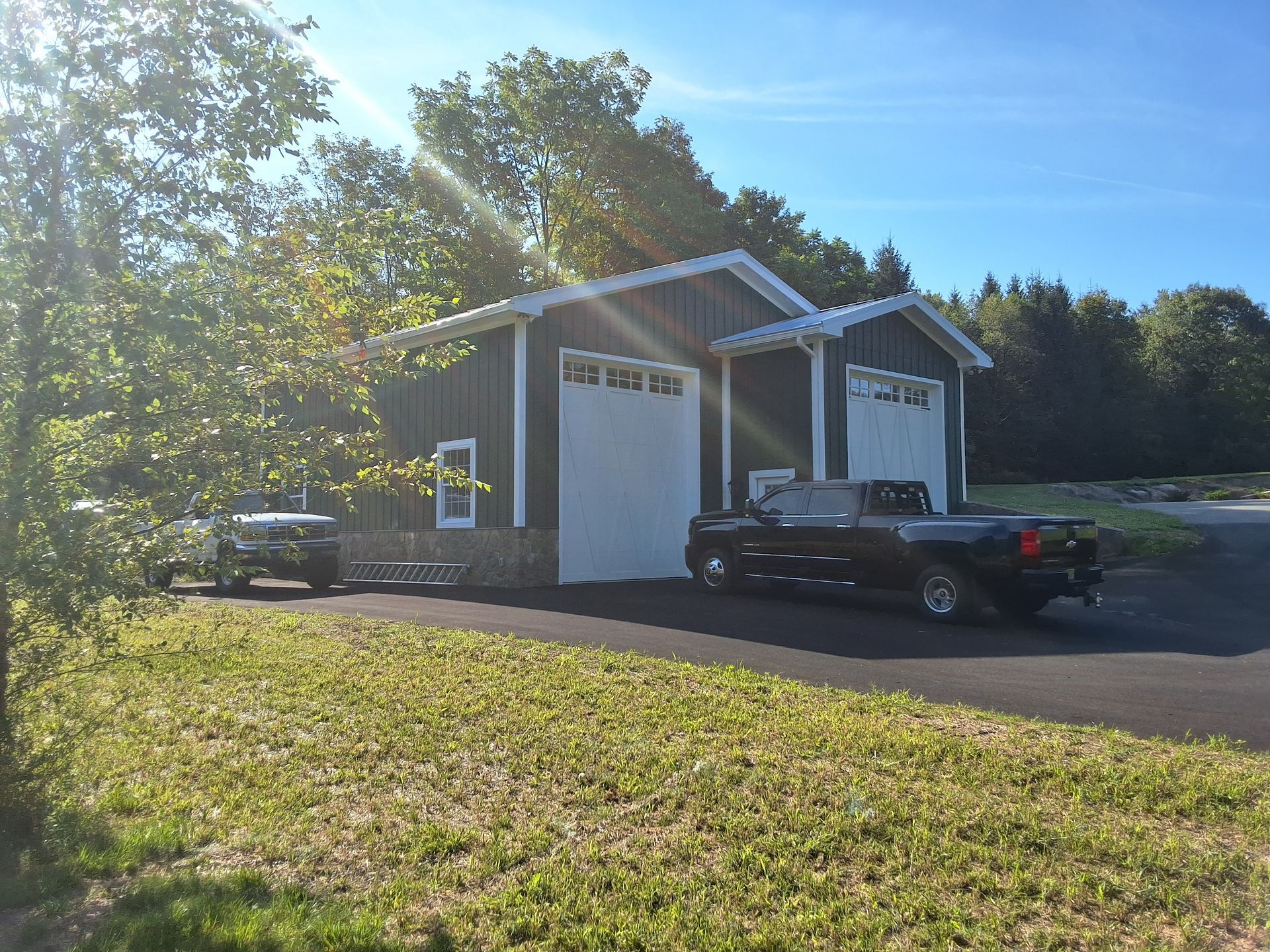 A black truck is parked in front of a garage