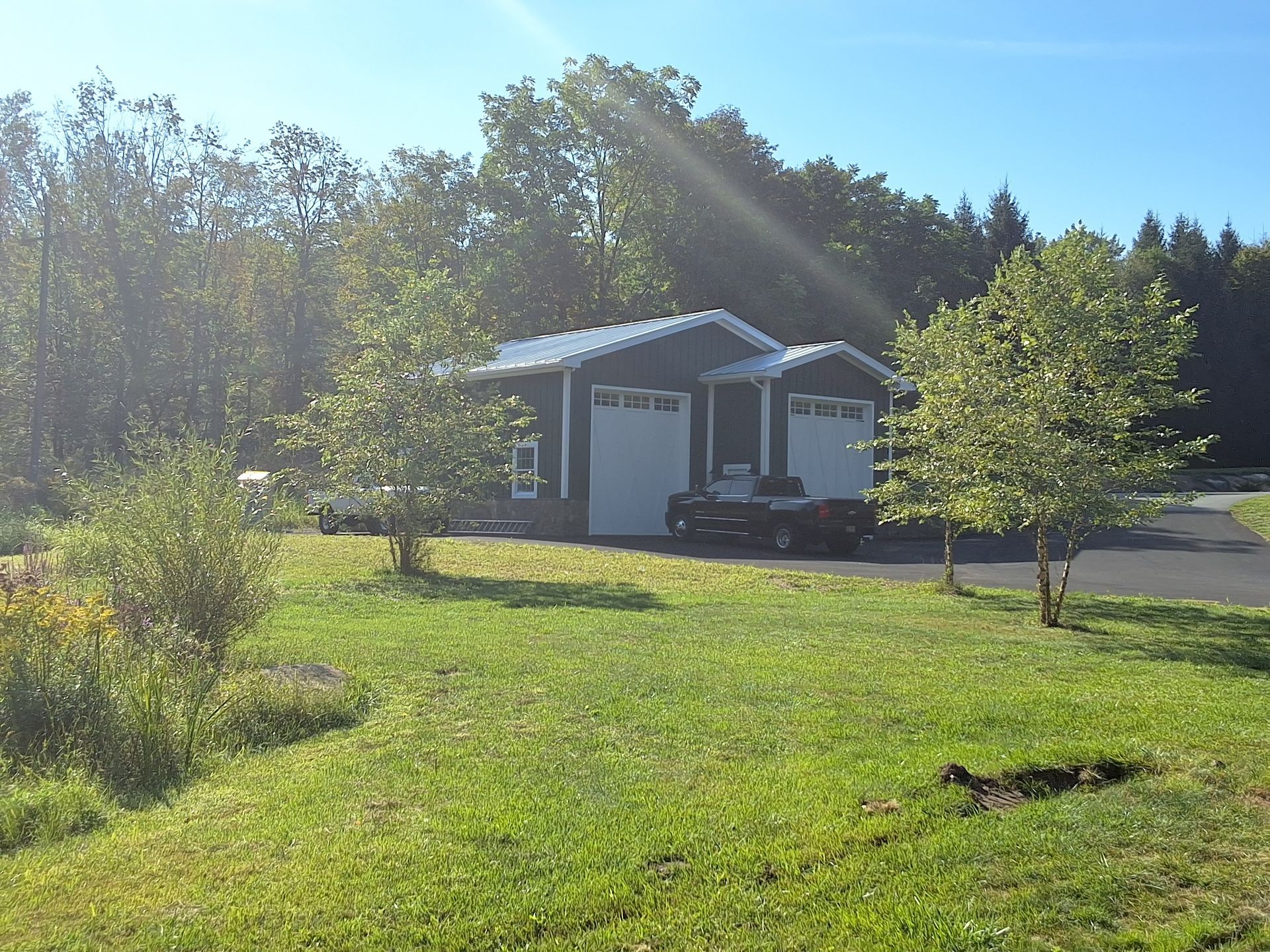 A garage with two cars parked in front of it