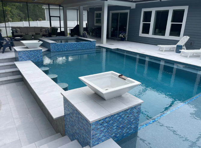 Pool with blue tile and white accents. Outdoor patio with lounge chairs.